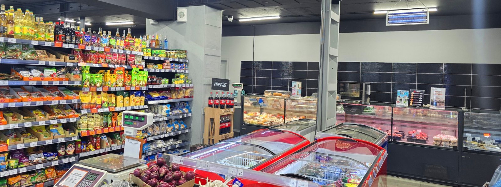 Interior de uma loja Gryadka com prateleiras abastecidas e refrigeração